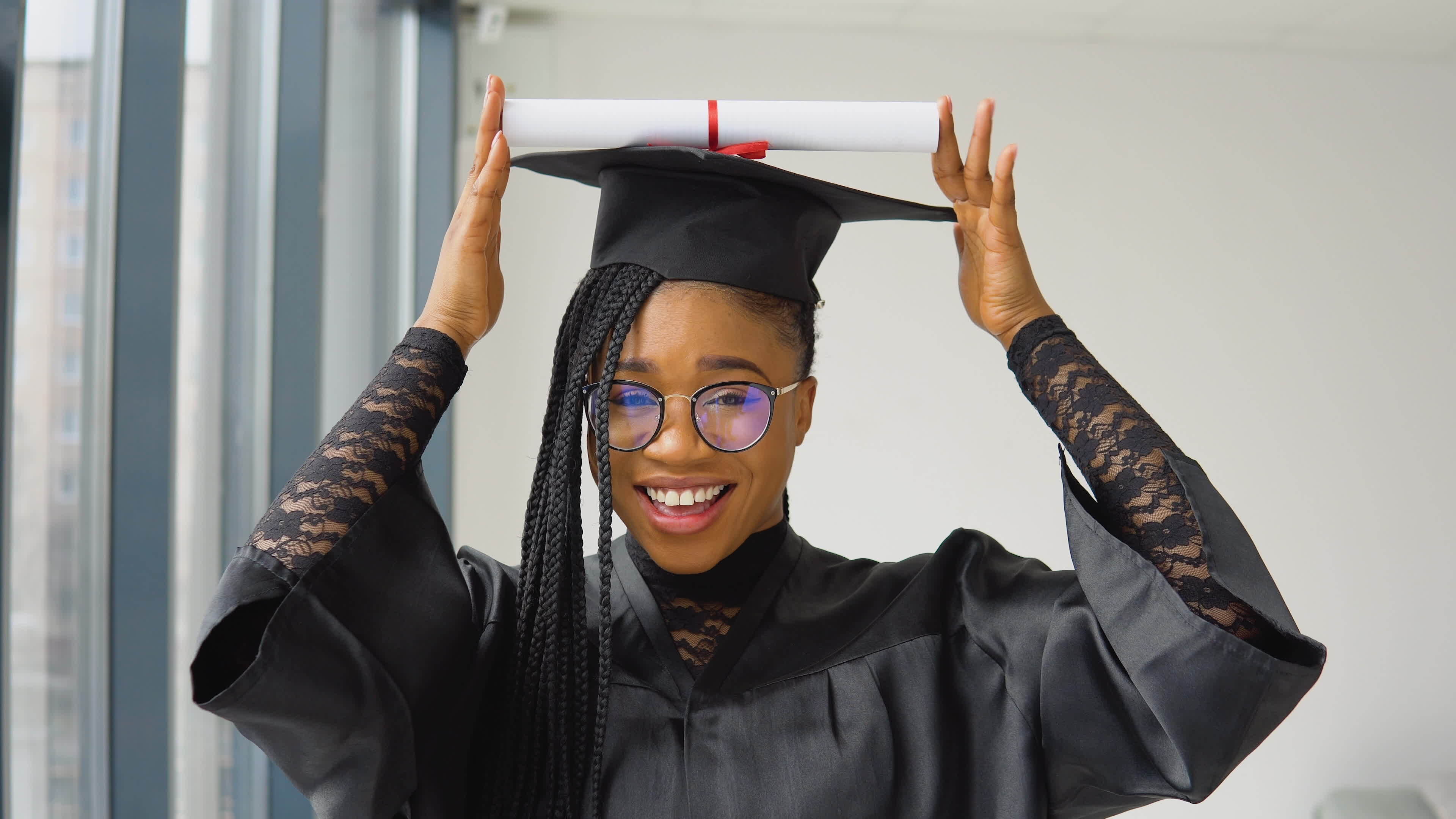 Graduate lifting her mortarboard