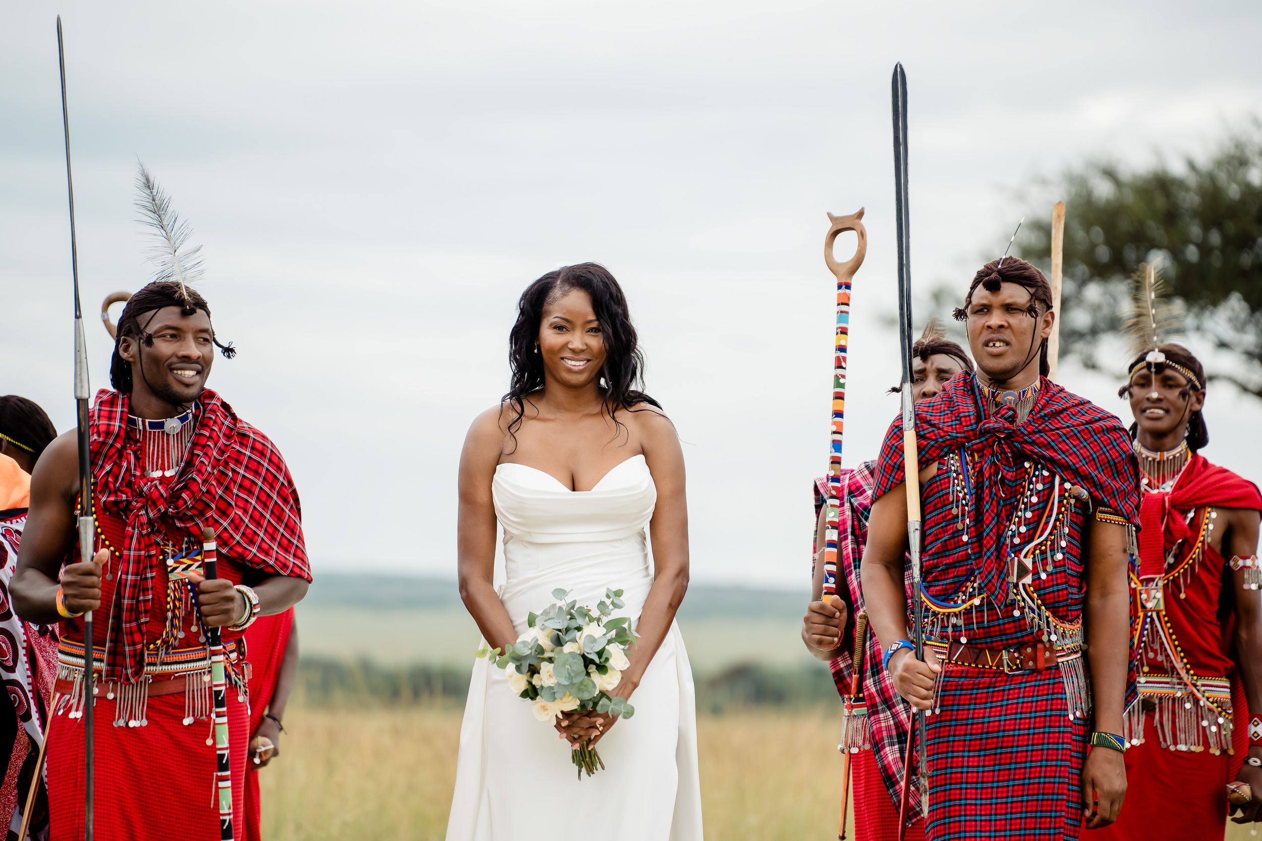 Bride walking beside Maasai wedding attendants